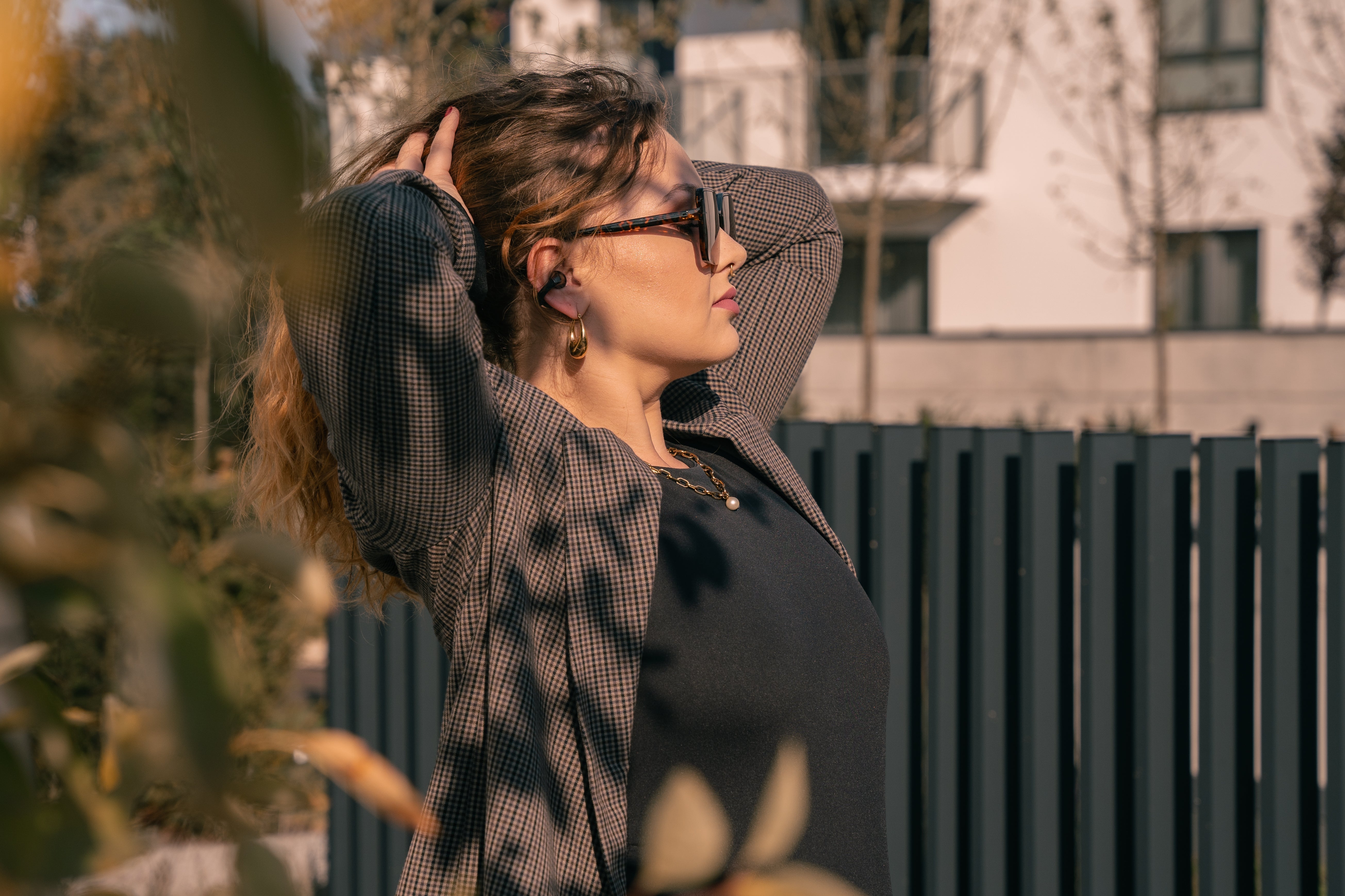 Frau mit offenen Ohrhörern im Freien – hören andere den Sound? Testen Sie Diskretion & Klangqualität bei Sonnenschein.
