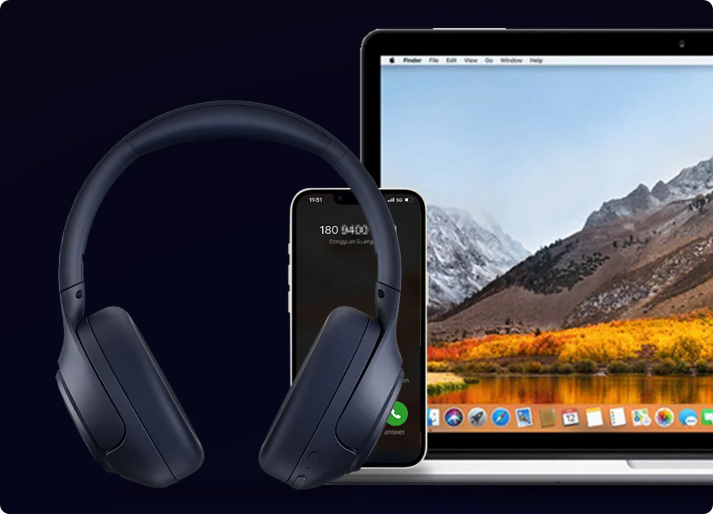 Dunkelblaue Over-Ear-Kopfhörer neben iPhone und MacBook mit Berg-Hintergrund.