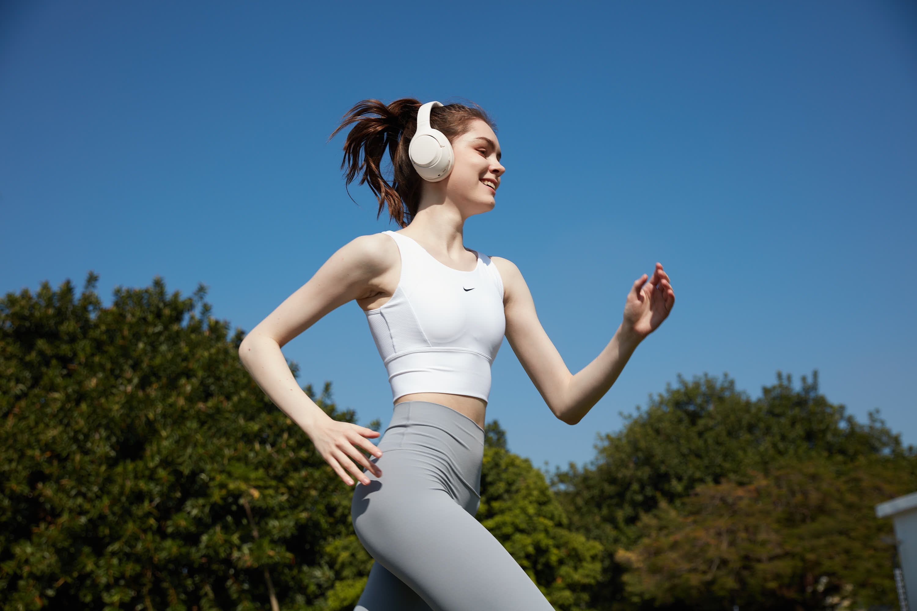 A girl in motion wearing QCY H3