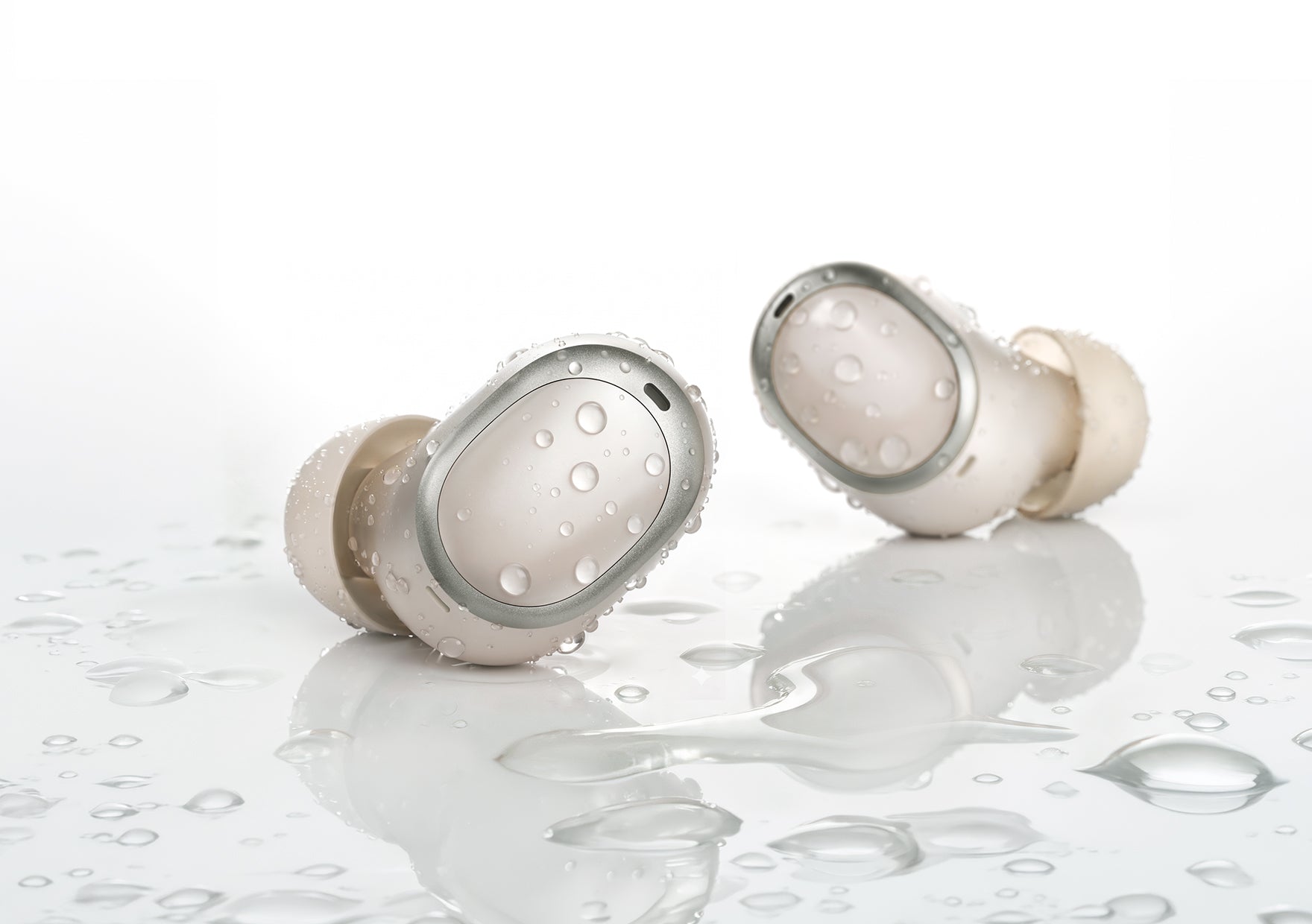 Wasserdichte weiße In-Ear-Kopfhörer mit Wassertropfen auf reflektierender Oberfläche.